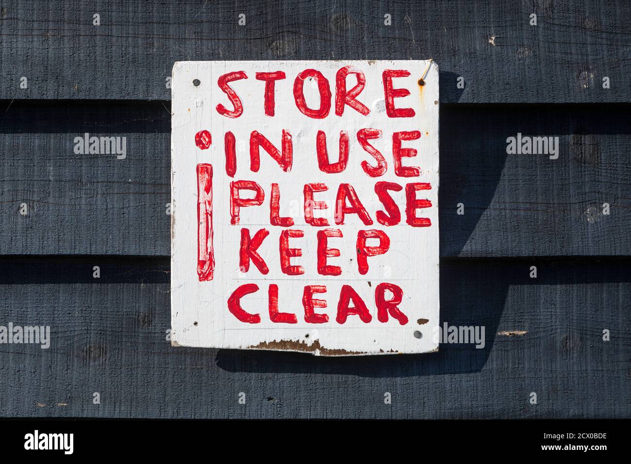 Un segno di tenere chiaro approssimativamente dipinto su un muro di legno Foto Stock