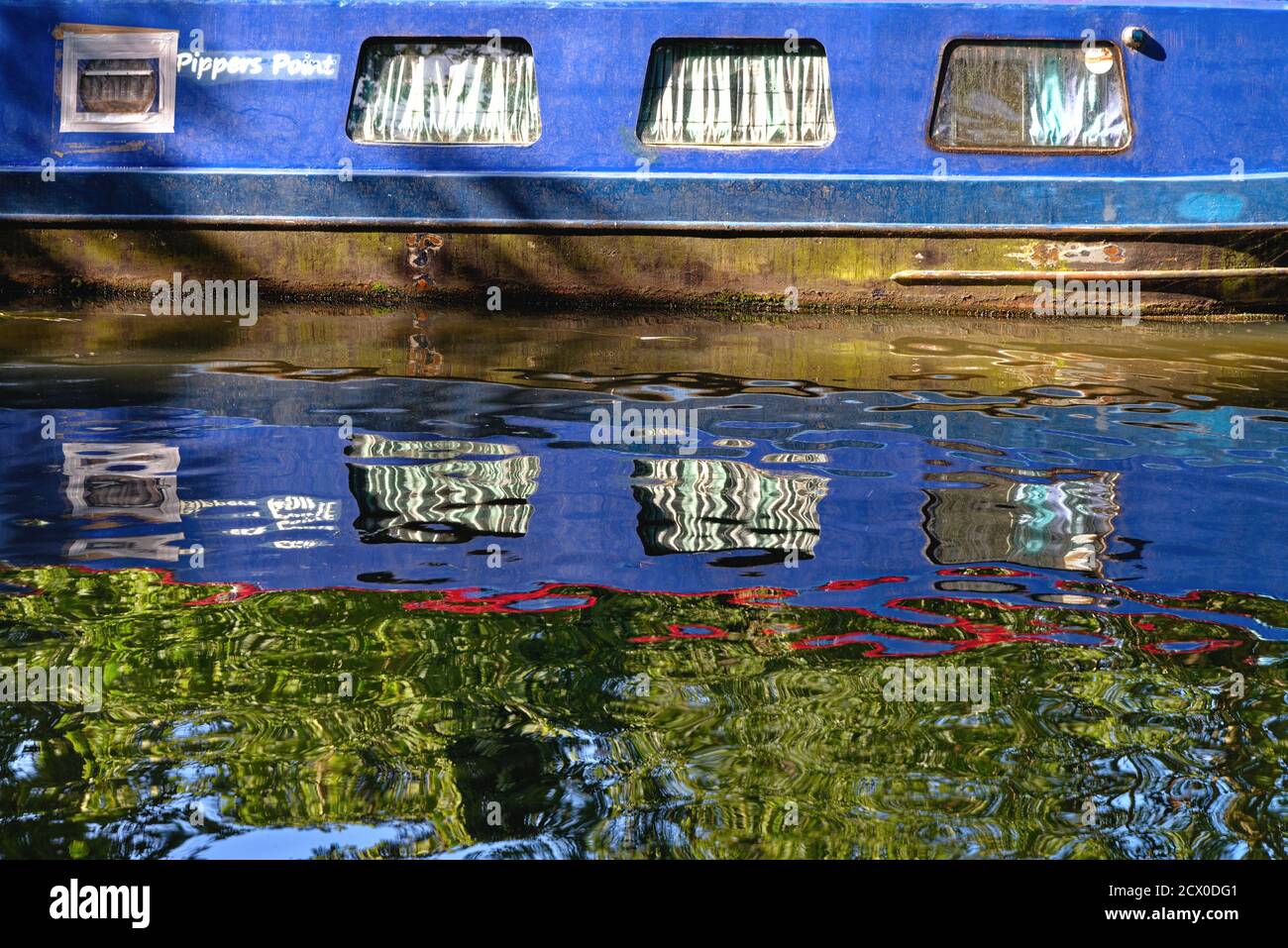 Forme astratte create dai riflessi di strette dipinte di luce barca in acqua Foto Stock