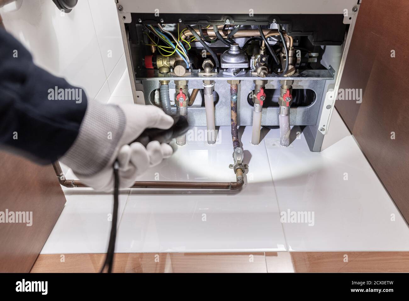 Tecnico che ispeziona un riscaldatore a gas o una caldaia di riscaldamento in una casa. Concetto di manutenzione Foto Stock