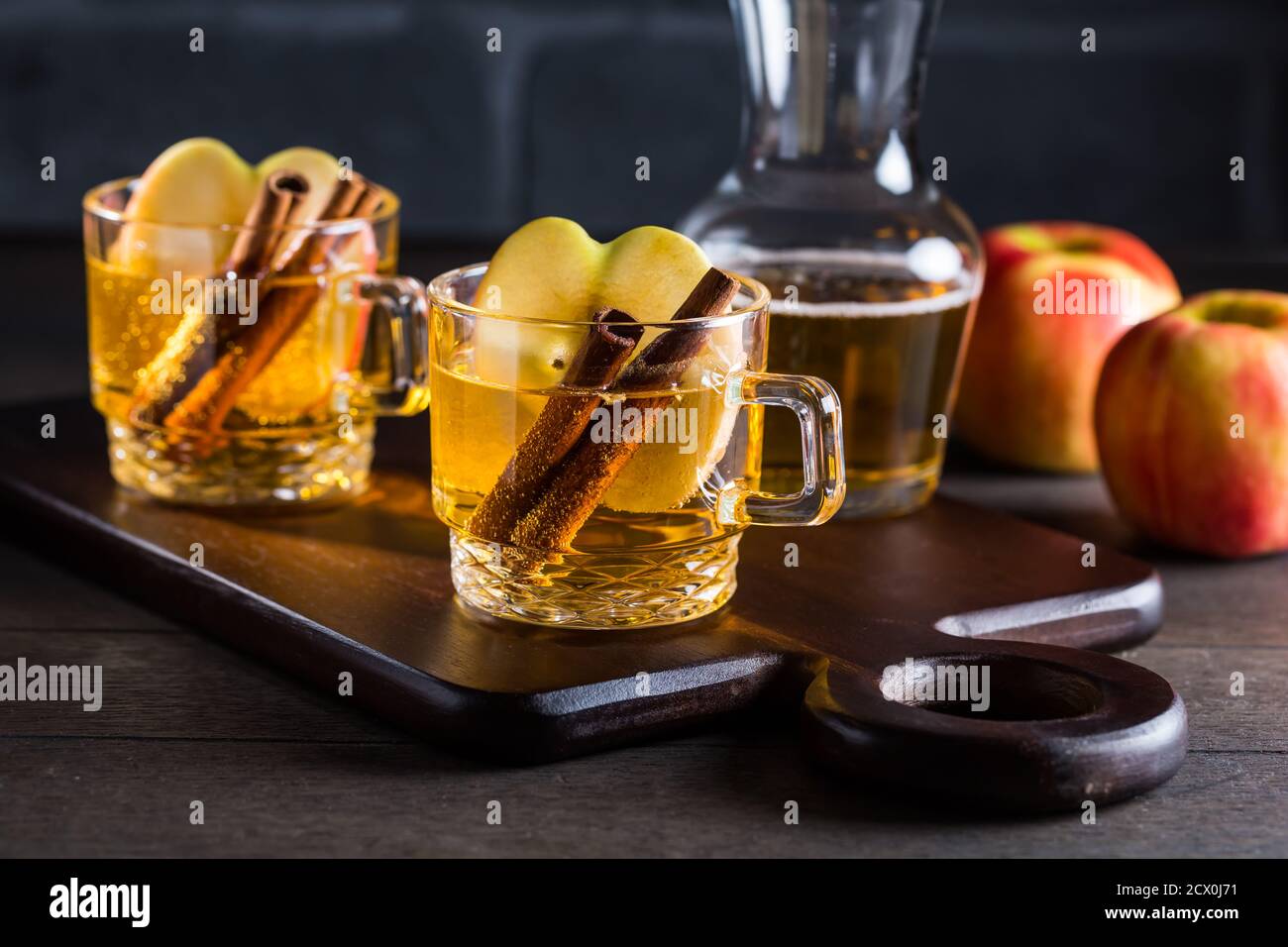 Cocktail caldo di sidro di mela con cannella e fette di mela. VIN brulé di mele per Natale. Foto Stock