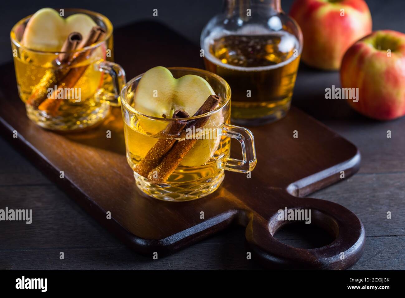 Cocktail caldo di sidro di mela con cannella e fette di mela. VIN brulé di mele per Natale. Foto Stock
