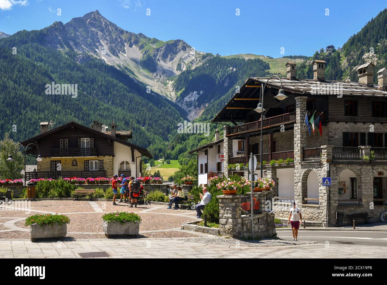 Vista su piazza Brochreel nel centro della famosa città di montagna con persone e backpackers in estate, Courmayeur, Valle d'Aosta, Italia Foto Stock