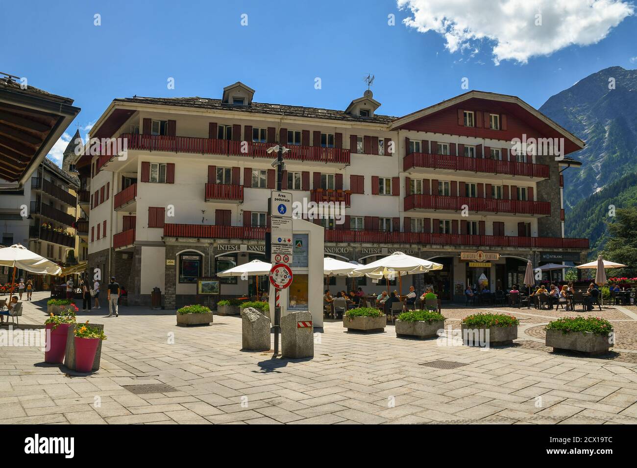 Vista su piazza Brochreel nel centro della famosa città di montagna con persone in caffè all'aperto in estate, Courmayeur, Valle d'Aosta, Italia Foto Stock