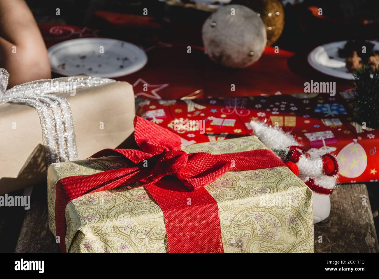 Un tavolo di campagna decorato con regali e oggetti di Natale durante Un picnic di Natale in natura Foto Stock