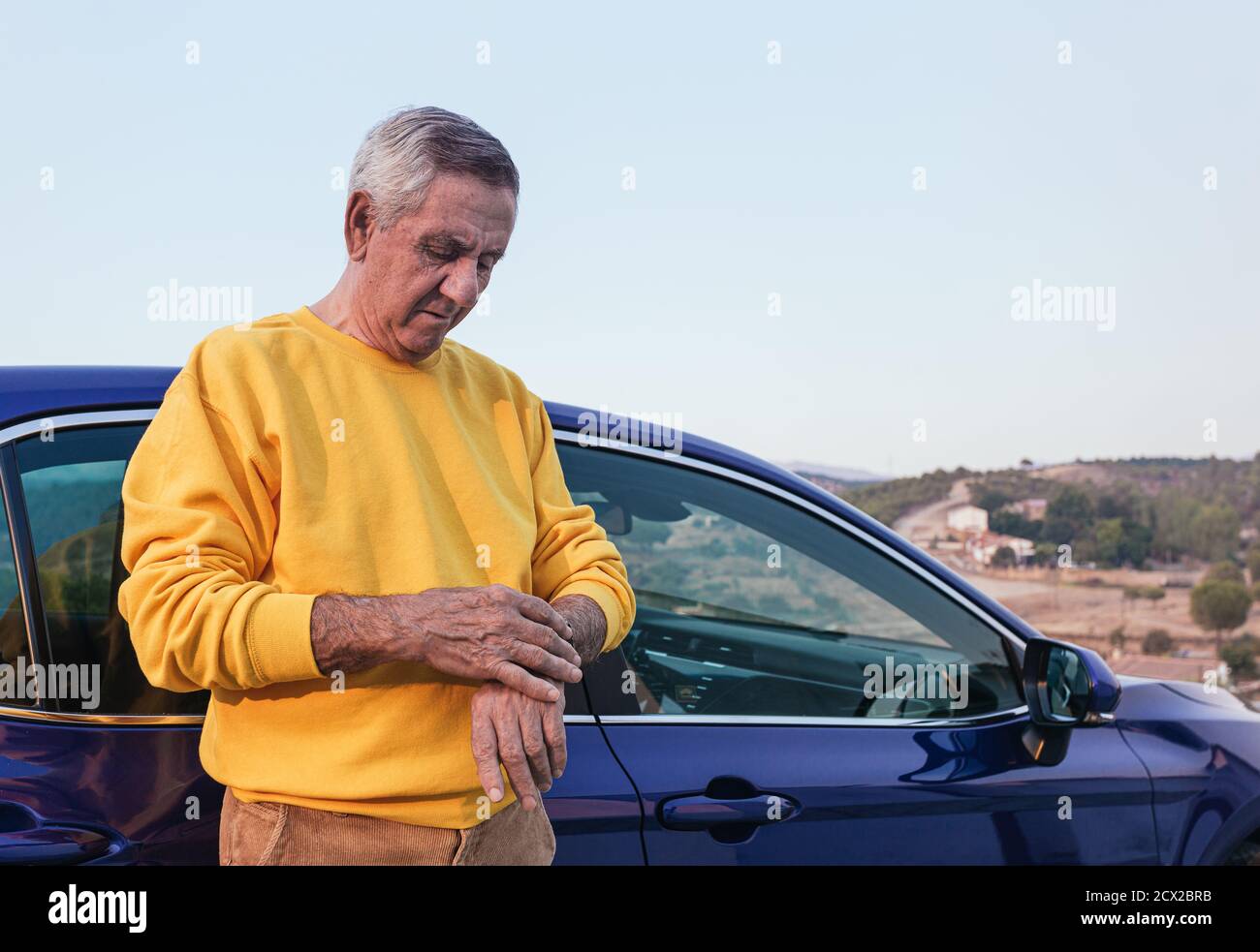 Tempo di controllo per i viaggiatori anziani vicino all'auto Foto Stock