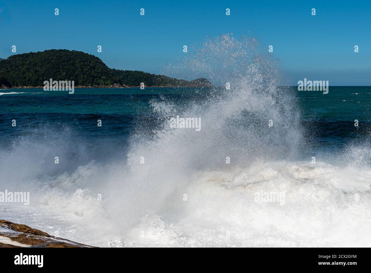 Schiuma bianca di onde che spruzzano sulla spiaggia brasiliana Foto Stock