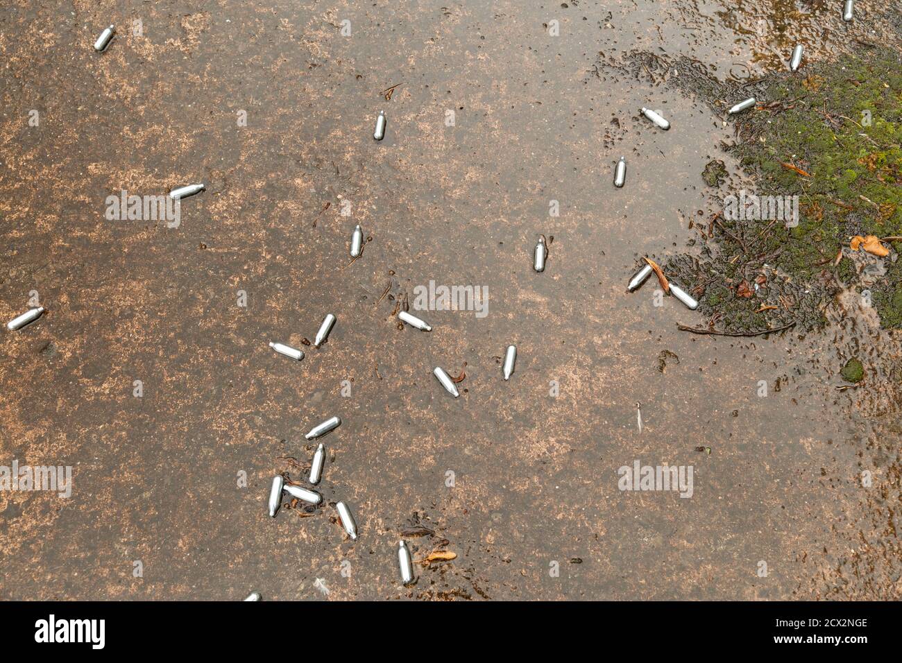 contenitori di protossido di azoto scartati sul pavimento bagnato. Ridendo barattoli a gas che litterano il pavimento. Problema della droga in Gran Bretagna ottobre 2020 Foto Stock