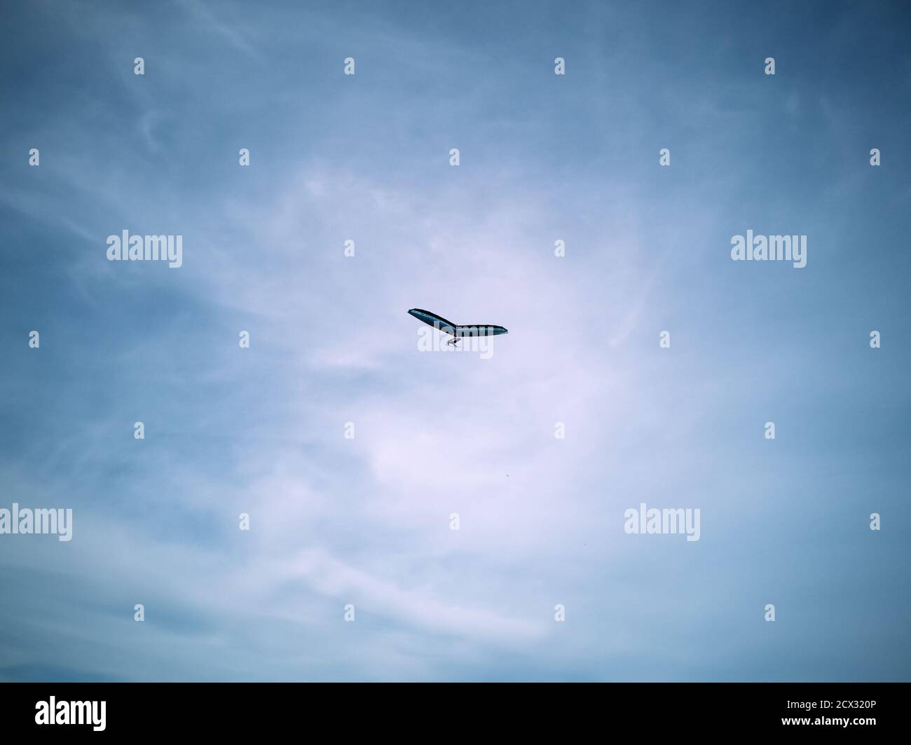 Parapendio blu che vola in alto in un bel cielo blu con nuvole di cirrus bianco a Khodosivka, Kyiv. Hobby di sport estremi. Foto Stock