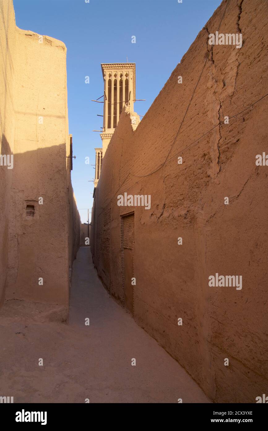 Le strette strade secondarie di adobe di Yazd, Iran. Un tower o un catcher del vento. Un tradizionale elemento architettonico persiano per creare una ventilazione naturale negli edifici Foto Stock