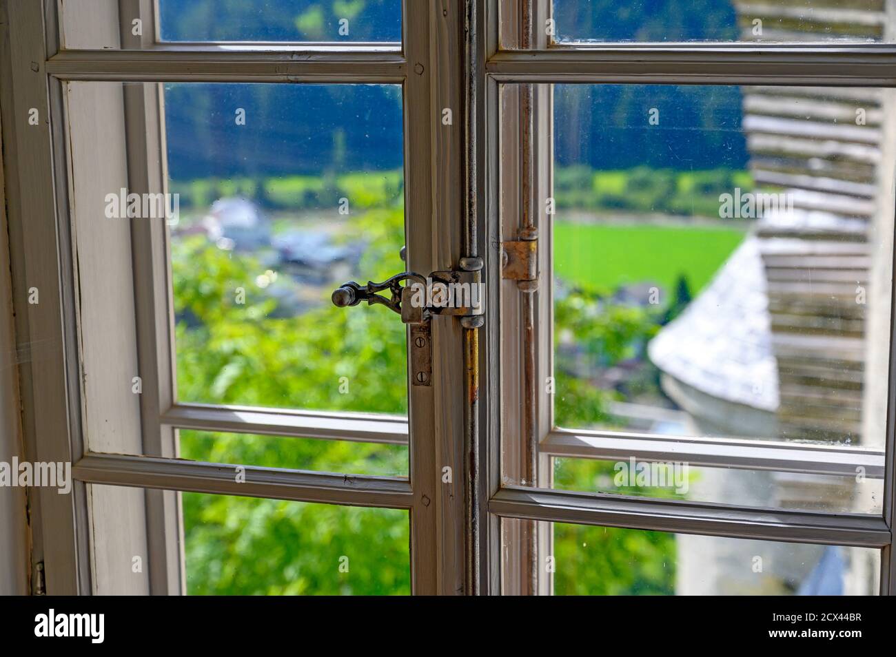 Vista attraverso una finestra con chiusura storica nel villaggio di Heinfels, Austria Foto Stock
