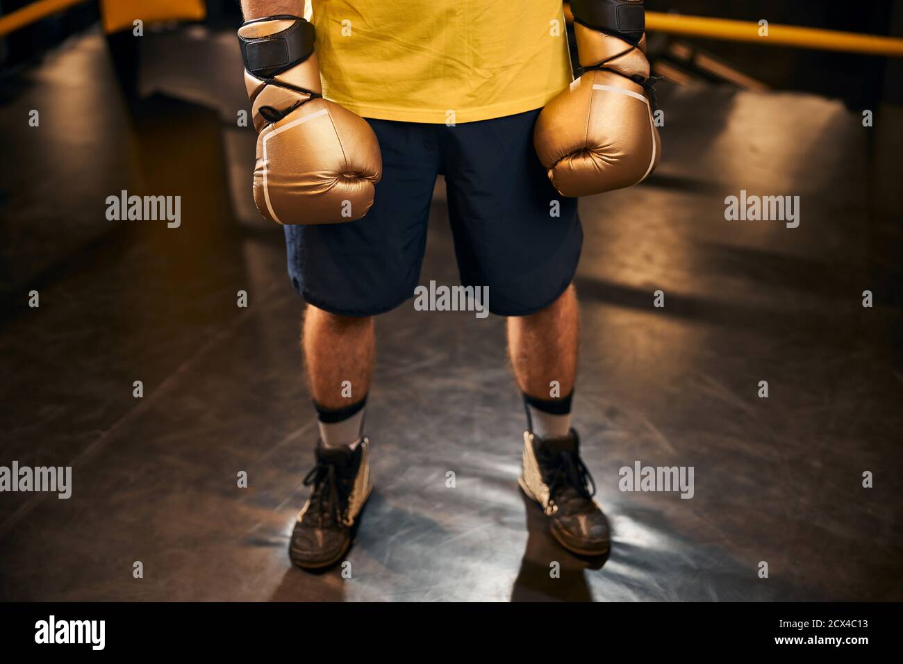 Uomo atletico in shorts in piedi su un pavimento ad anello Foto Stock