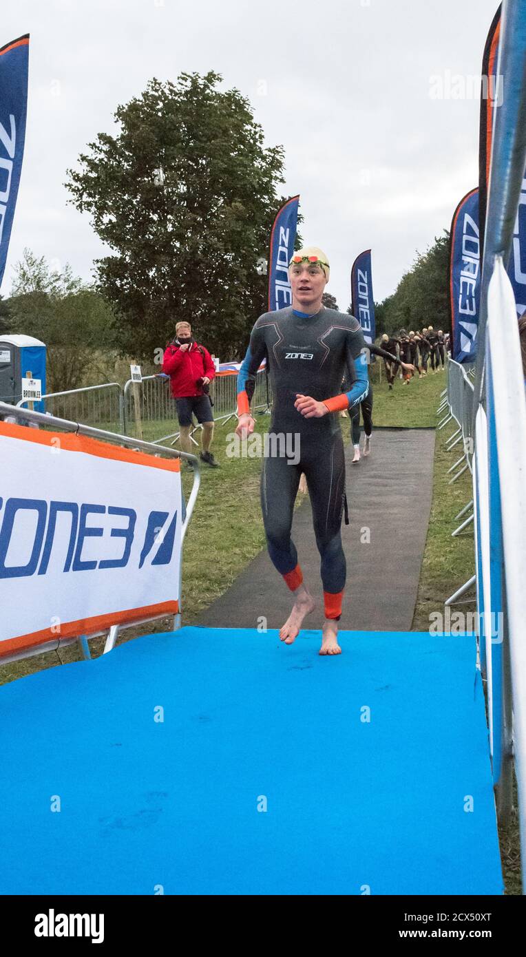 Atleti professionisti Elite maschili che si preparano per il primo evento, nuoto, all'ultimo triathlon dell'anno nelle loro mute. Foto Stock