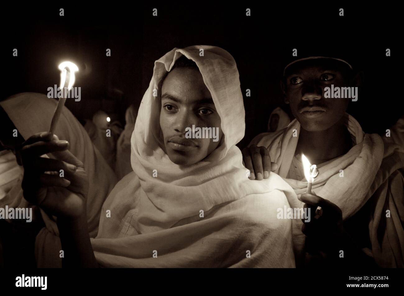 Pellegrini etiopi e adoratori che celebrano Fasika nella chiesa di Bet Medhame Alem. Pasqua, Lalibela, Etiopia UN Kuta è un tessuto fatto a mano molti uomini etiopi usano per coprire la testa e le spalle quando indossano abiti fatti di chiffon, specialmente quando frequentano la chiesa. È costituito da due strati di tessuto Foto Stock