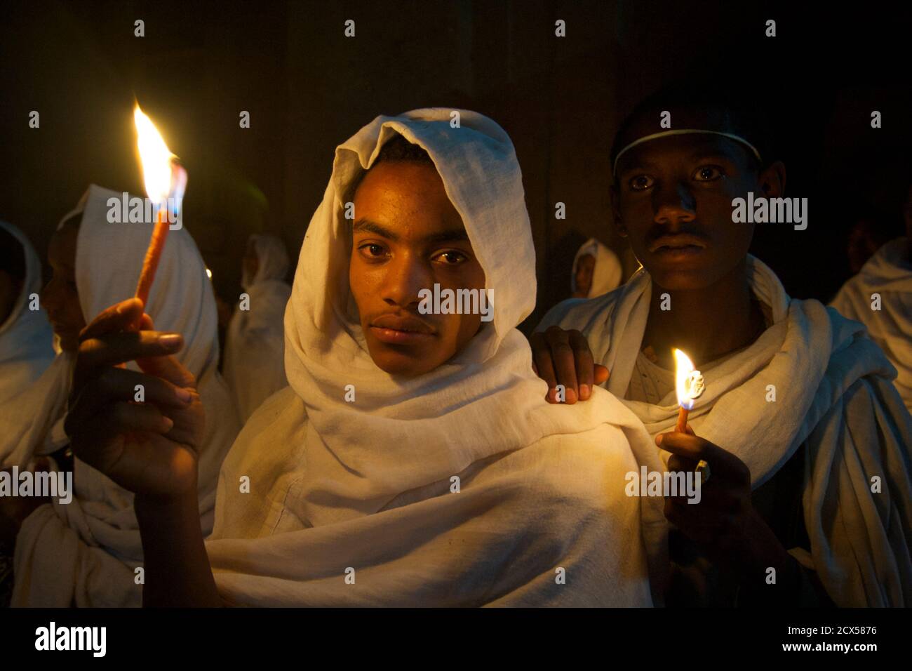 Pellegrini etiopi e adoratori che celebrano Fasika nella chiesa di Bet Medhame Alem. Pasqua, Lalibela, Etiopia UN Kuta è un tessuto fatto a mano molti uomini etiopi usano per coprire la testa e le spalle quando indossano abiti fatti di chiffon, specialmente quando frequentano la chiesa. È costituito da due strati di tessuto Foto Stock