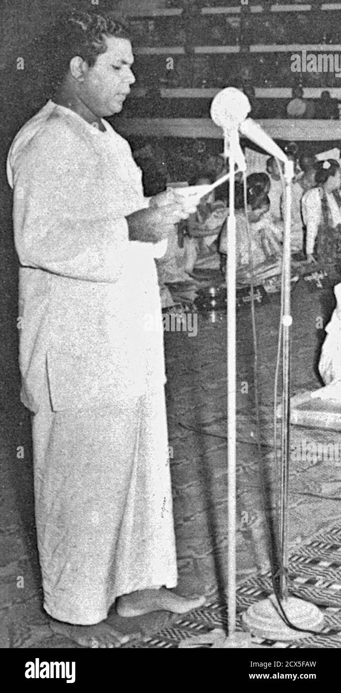 Didascalia originale: Ananda Wahihana Palliya Guruge Segretario Generale della LankÄ Bauddha Mandalaya legge un messaggio del primo ministro ceilonese S. W. R. D. Bandaranaike al Consiglio Buddista (Chaá¹­á¹­a SangÄyanÄ) a Rangoon 1956-04-23. Foto Stock