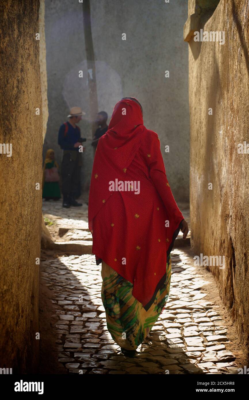 Donna etiope che cammina attraverso le strette strade della città vecchia, Harar Foto Stock