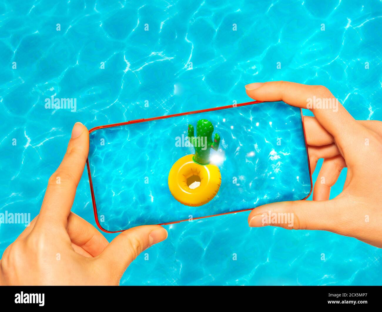 Il telefono cellulare di tenuta delle mani che scatta la foto con buoy gonfiabile del cactus anello in piscina Foto Stock