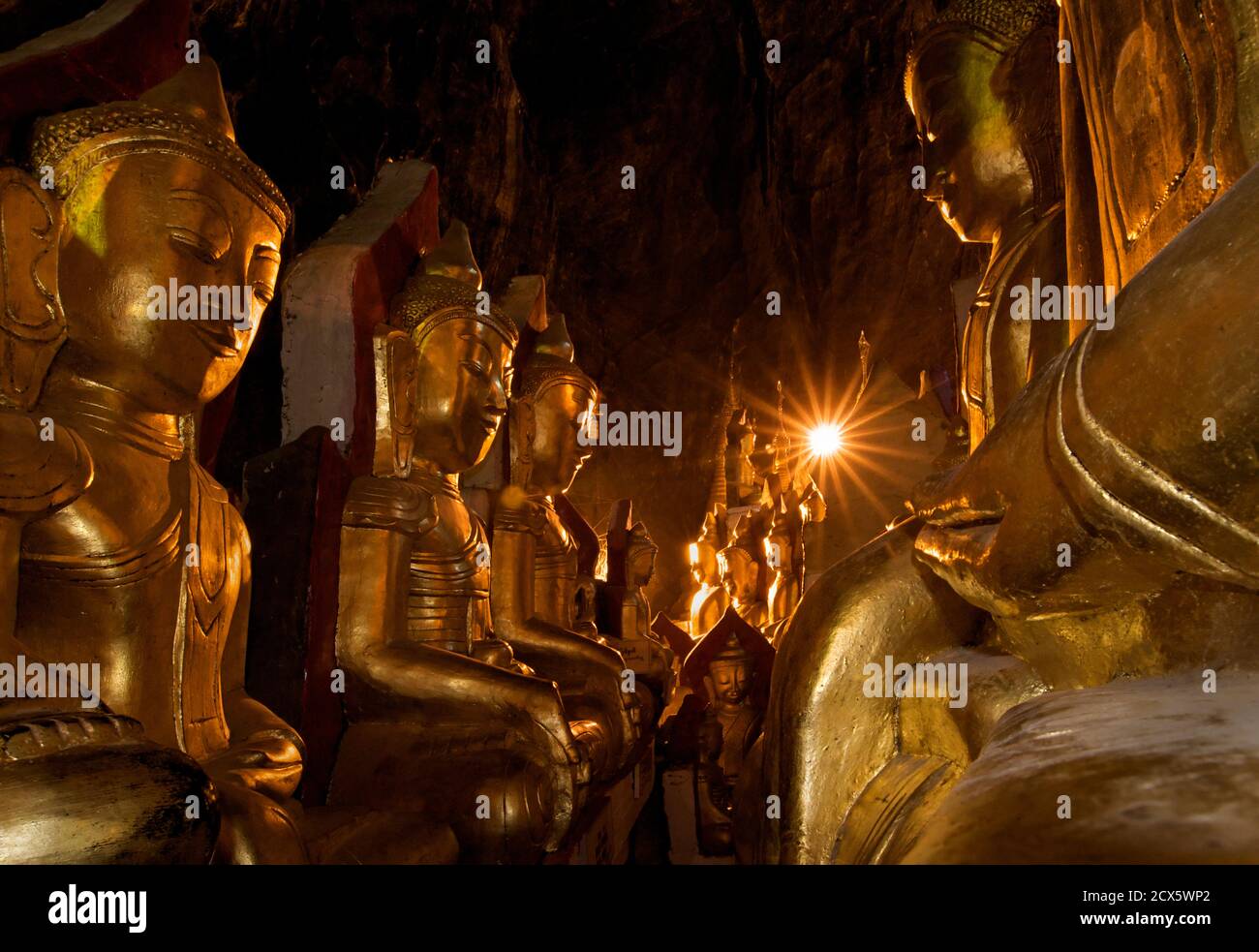 Dorare le immagini del Buddha nelle grotte di Pindaya, stato Shan, Birmania. Myanmar Foto Stock