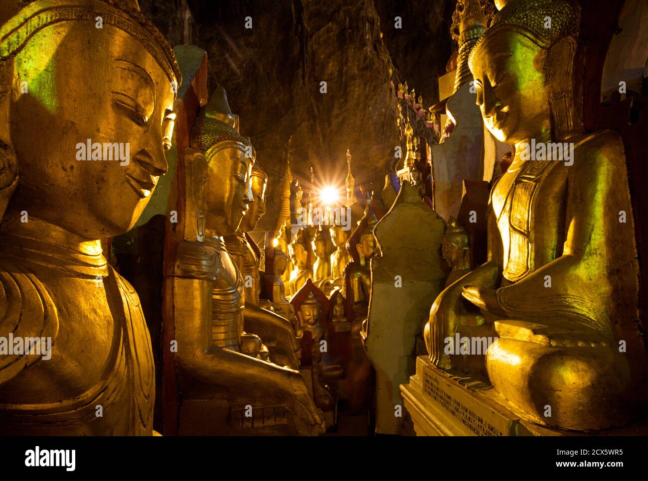 Dorare le immagini del Buddha nelle grotte di Pindaya, stato Shan, Birmania. Myanmar Foto Stock