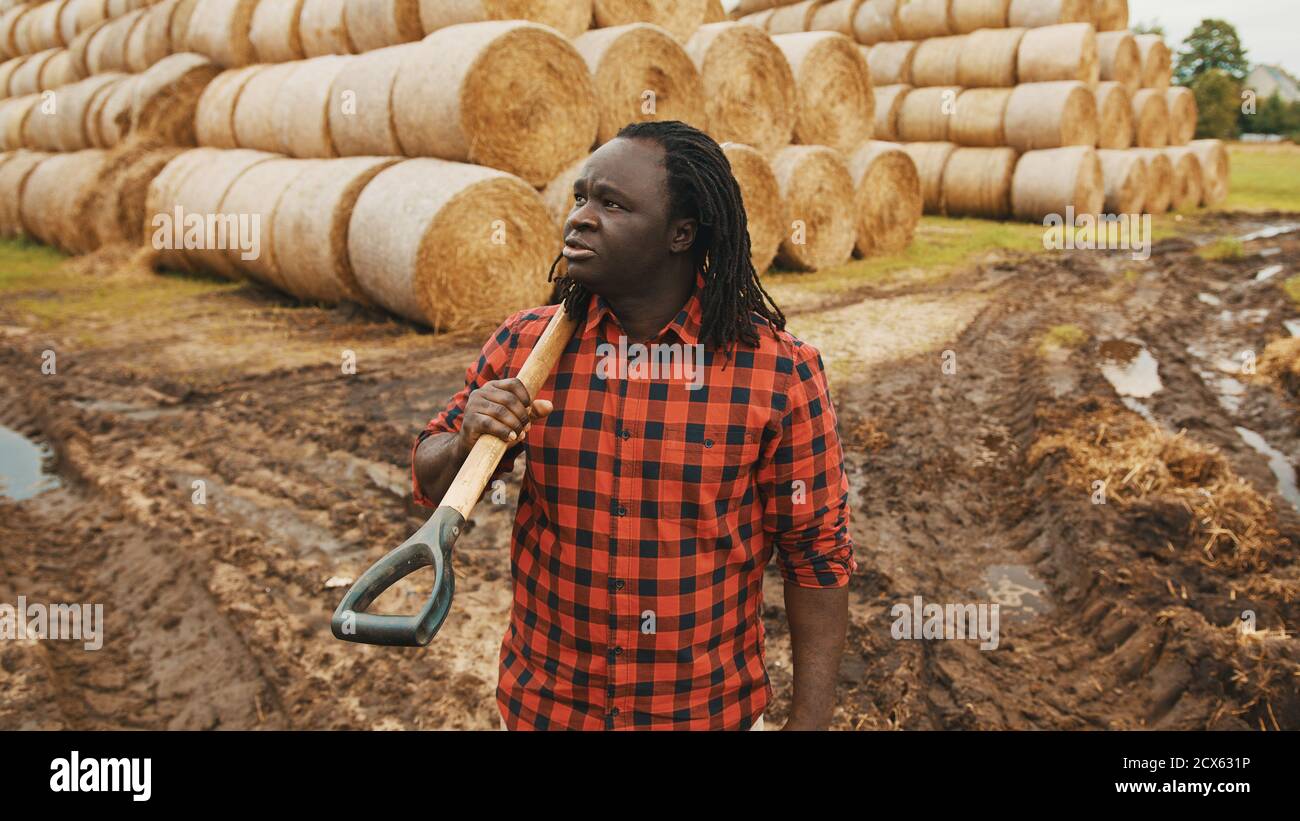 Ritratto di giovane agricoltore africano con forchetta a caraffa sulle spalle. Foto di alta qualità Foto Stock