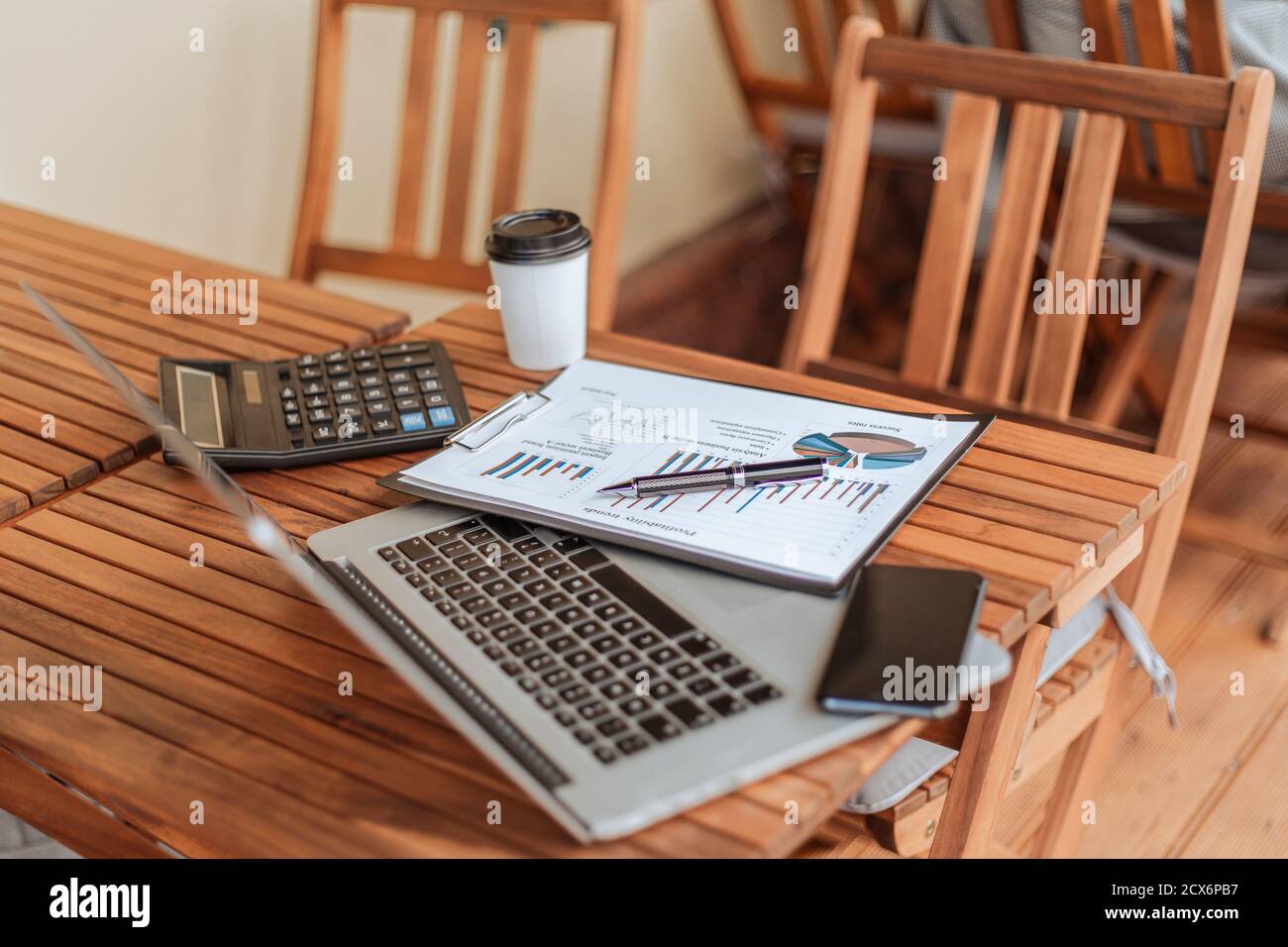 vista dall'alto. caffè da asporto, grafico finanziario e computer portatile sul tavolino da caffè. Foto Stock