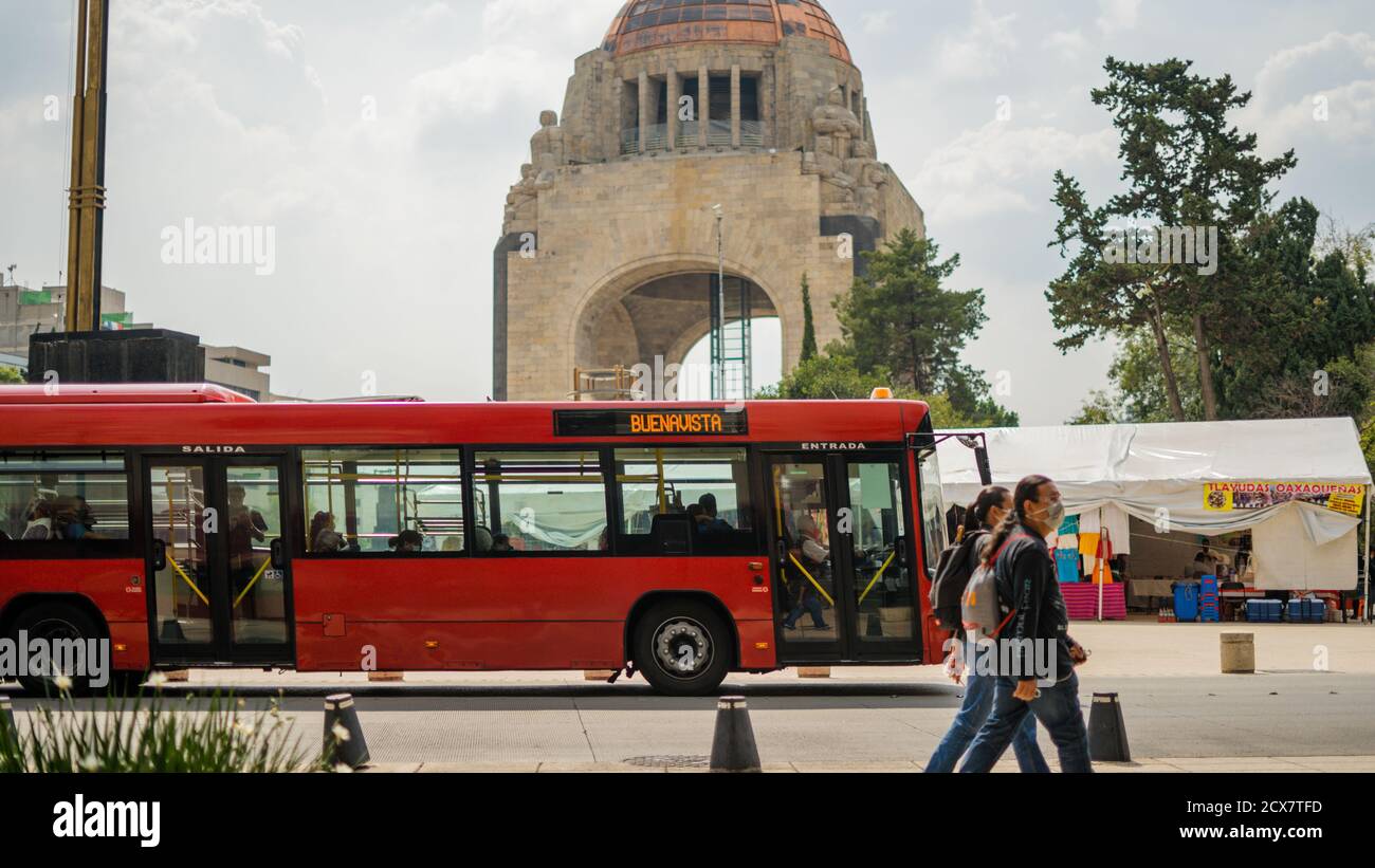 Pedoni e un autobus rosso che passa davanti al Monumento Foto Stock