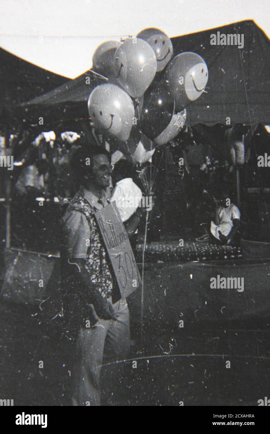 Bella fotografia in bianco e nero degli anni '70 di un uomo mongolfiera che  vende palloncini in una fiera di strada carnevale Foto stock - Alamy