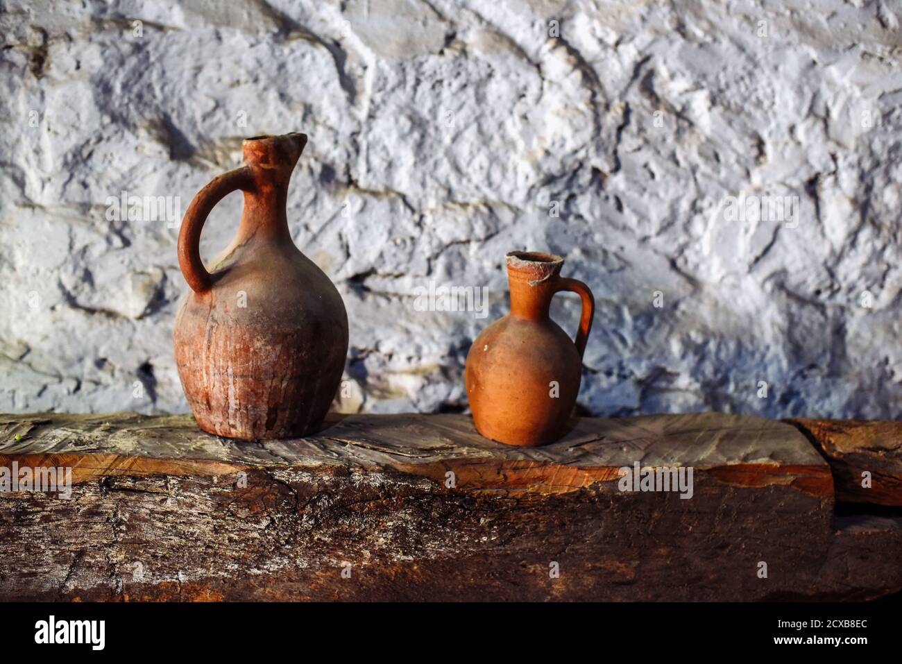 Varie vecchie caraffe, piatti di enologo su una mensola in legno nella cantina Foto Stock