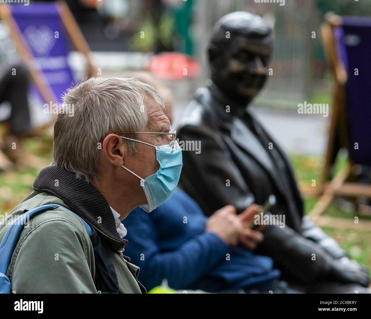 Londra, Gran Bretagna. 30 settembre 2020. Un uomo che indossa una maschera siede accanto alla statua di Bean a Leicester Square nel centro di Londra, Gran Bretagna, il 30 settembre 2020. Mercoledì il primo ministro britannico Boris Johnson ha promesso di adottare ulteriori misure per contenere l'aumento del tasso di infezione da coronavirus se la situazione continua a peggiorare nel paese.altre 7,108 persone in Gran Bretagna hanno dato risultati positivi per COVID-19, portando il numero totale dei casi di coronavirus nel paese a 453,264; Secondo le cifre ufficiali rilasciato Mercoledì. Credit: Han Yan/Xinhua/Alamy Live News Foto Stock