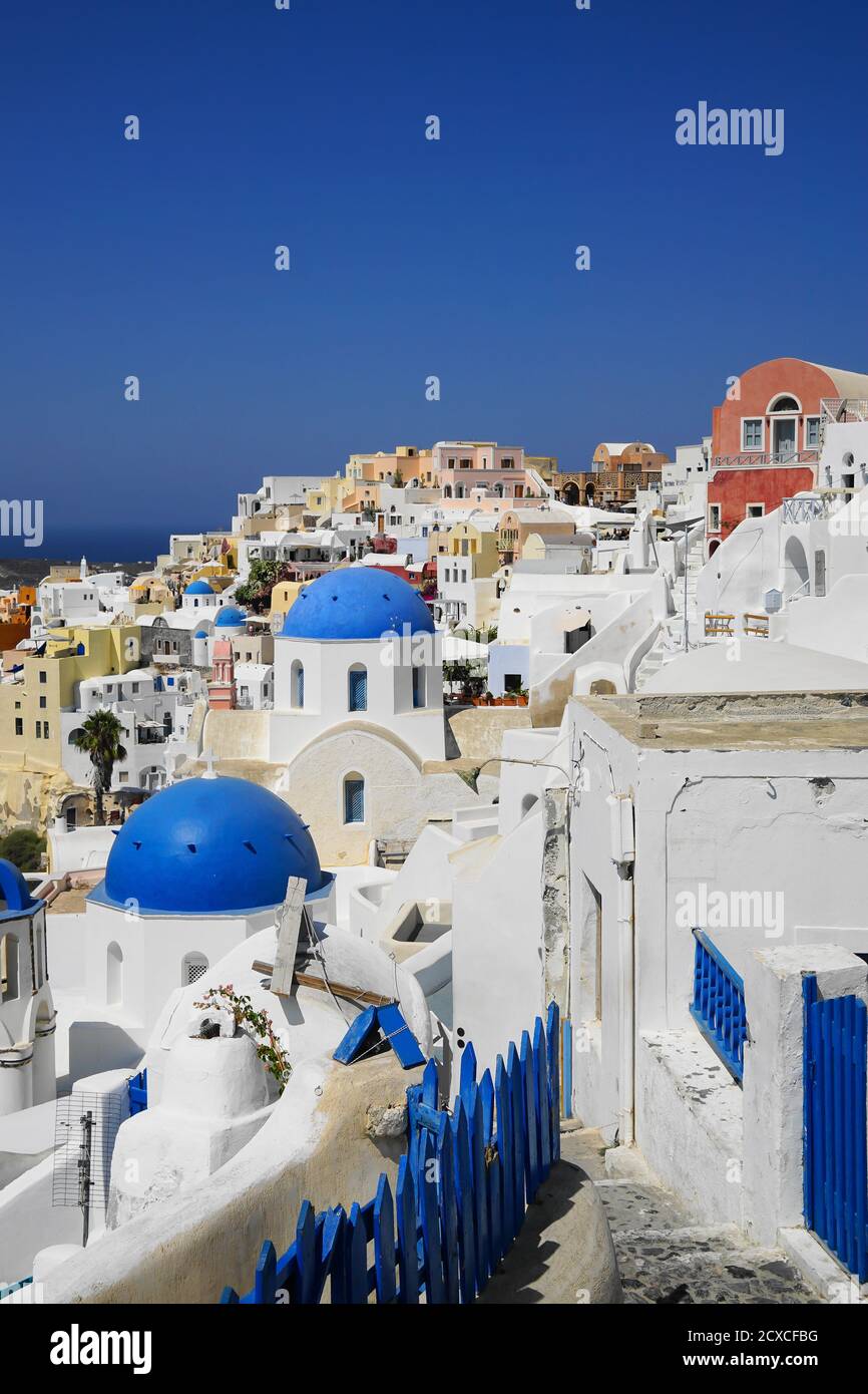 Recinzione blu, strade tortuose e splendidi edifici a Santorini Foto Stock