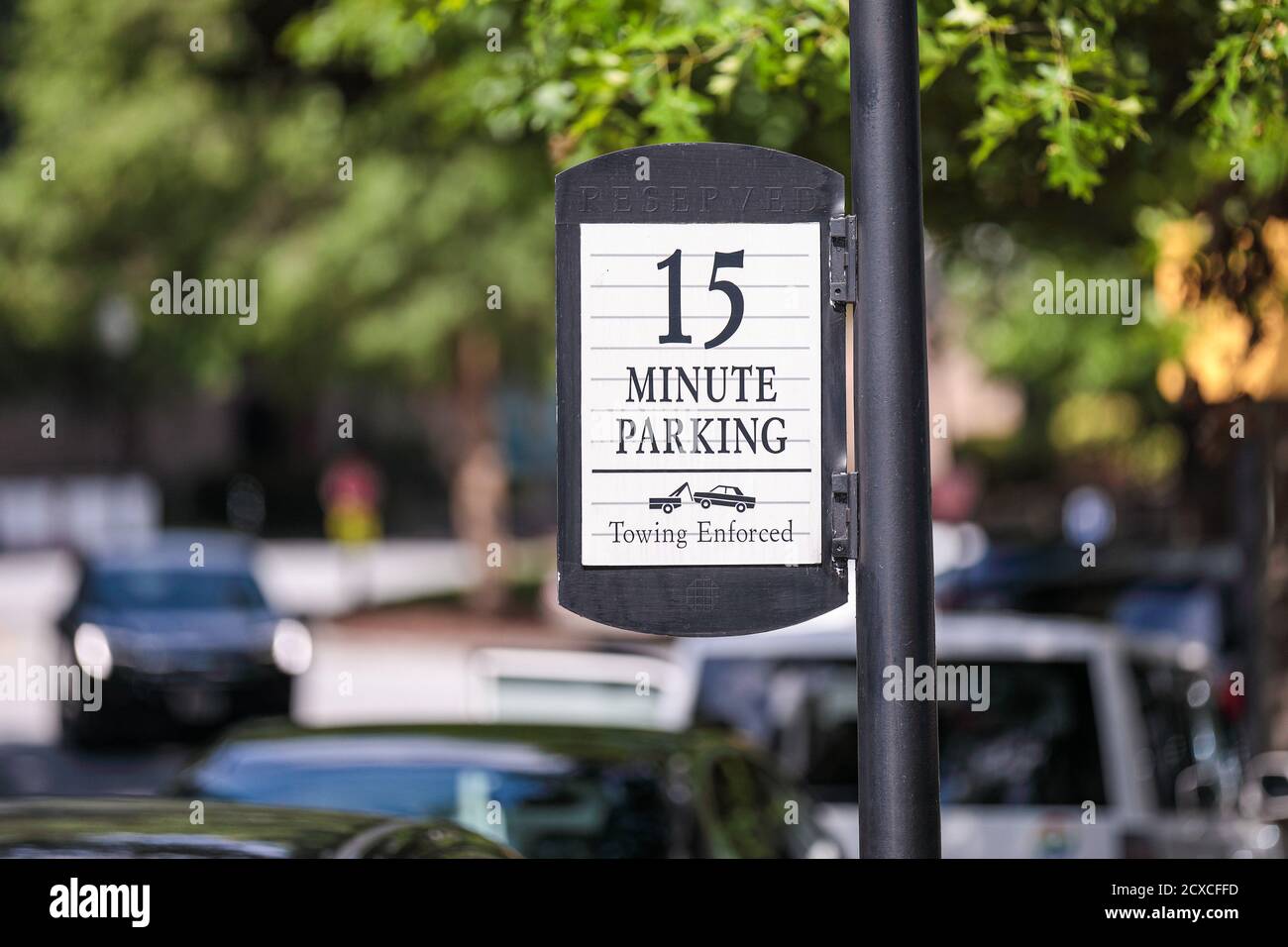 Cartello postato "15 minuti di parcheggio" con l'icona di traino Foto Stock