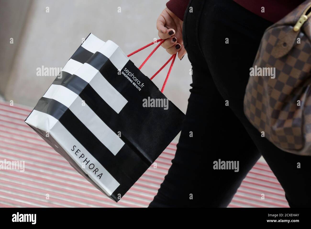 Una donna cammina con una borsa per la spesa Sephora mentre lascia un  negozio Sephora a Parigi il 23 luglio 2014. Sephora, il top seller di Dior  Lip Gloss e Lancome faccia
