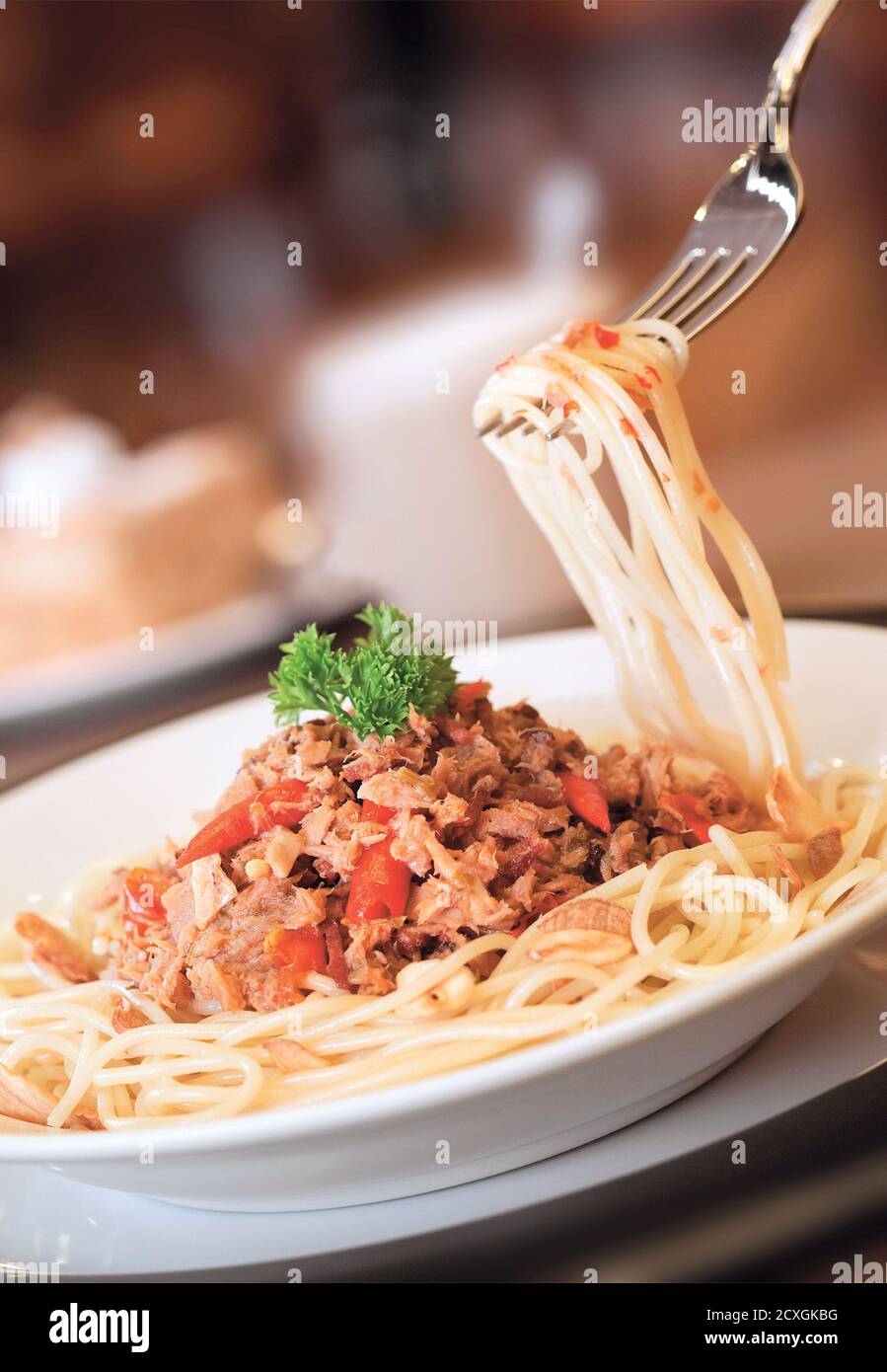 Vortice di spaghetti con carne tritata e fiocchi di peperoncino rosso su una forca Foto Stock