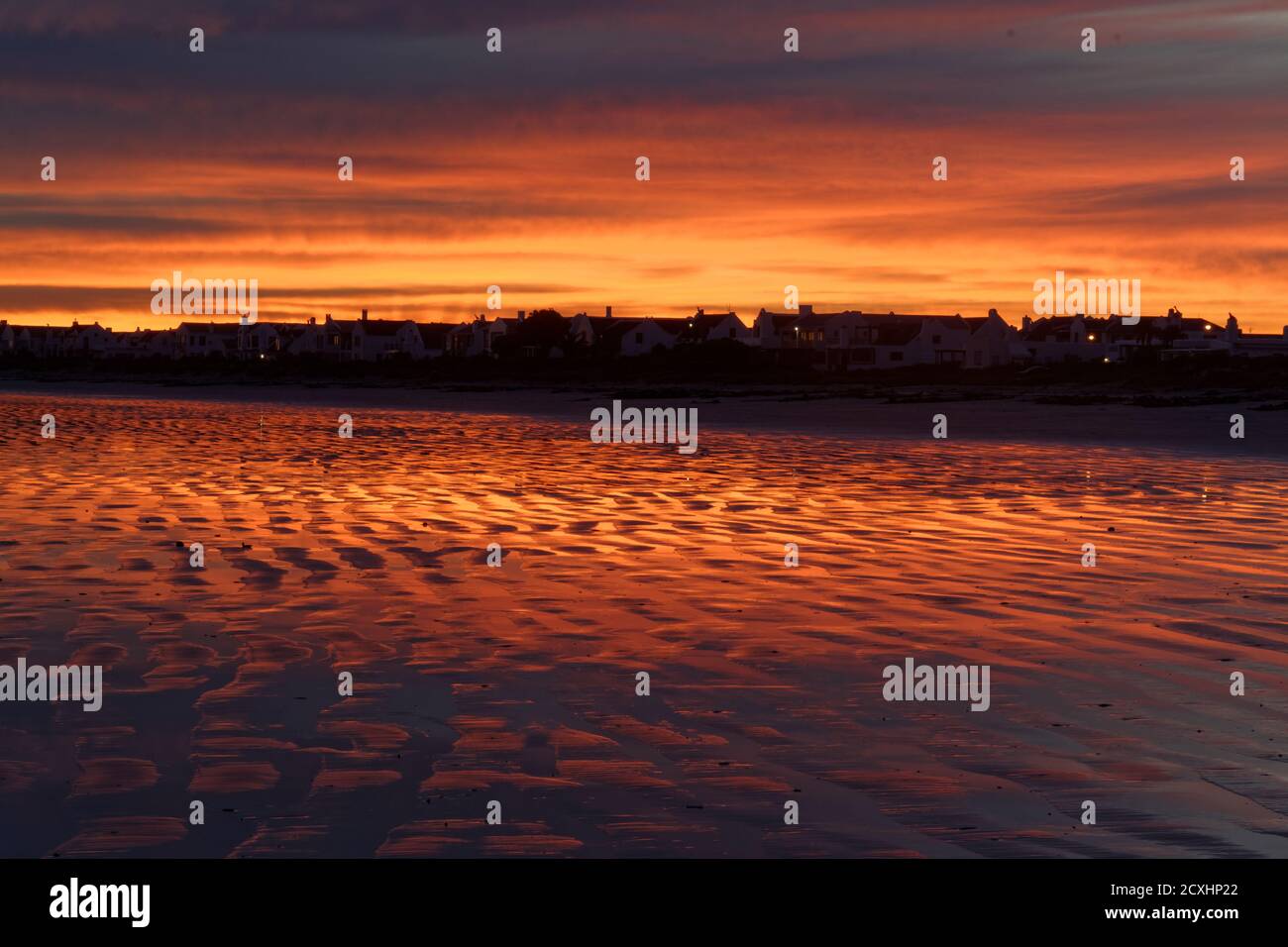 All'alba prima dell'alba, dando un meraviglioso colore rosso/arancione al cielo e alla spiaggia. Spiaggia di Paternoster nel Capo Occidentale, Sud Africa Foto Stock