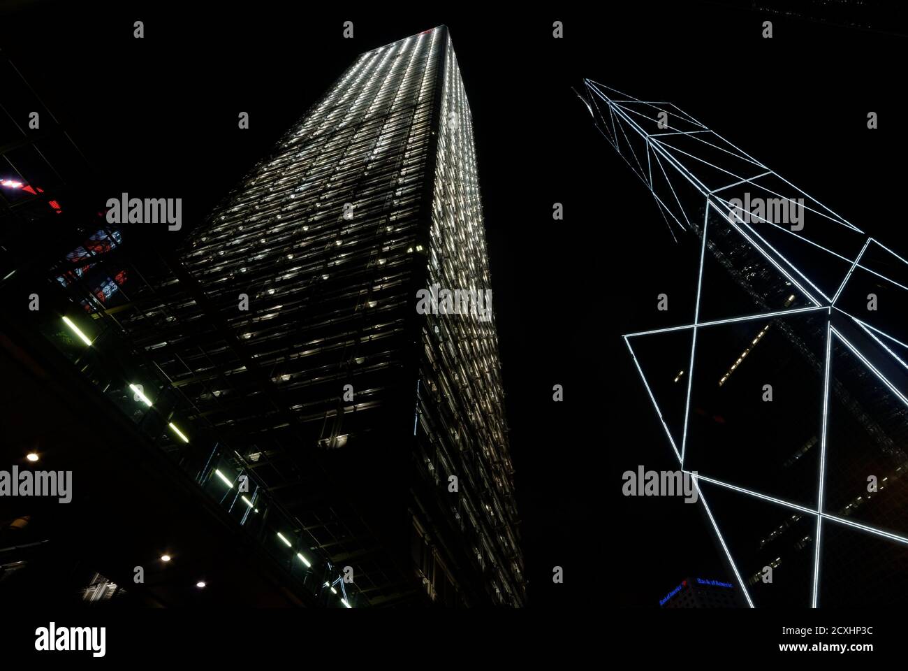 Grattacieli di Hong Kong di notte. Inquadratura angolata verso l'alto per una buona visione di luci e dettagli dell'edificio diversi Foto Stock