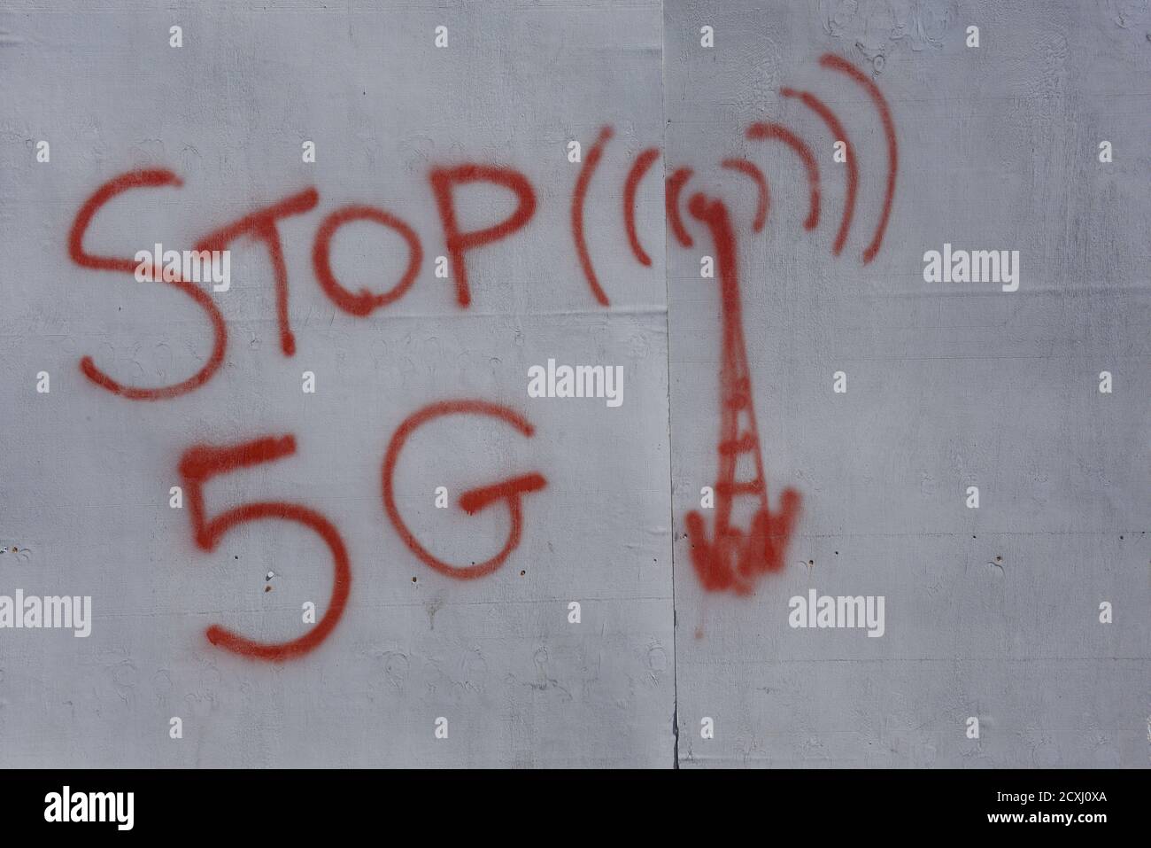 Graffiti circa 5G - 'Stop 5G' vernice rossa su un viso grigio di legno. Foto Stock