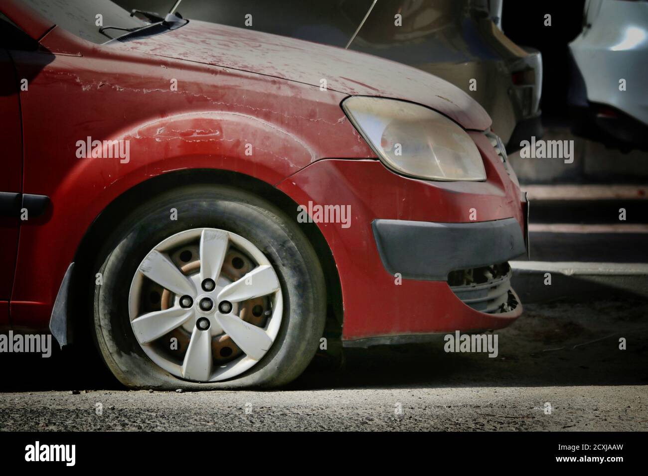Vista di uno pneumatico della vettura forato. Il trie sgonfio è un problema comune con i veicoli e potrebbe causare incidenti Foto Stock