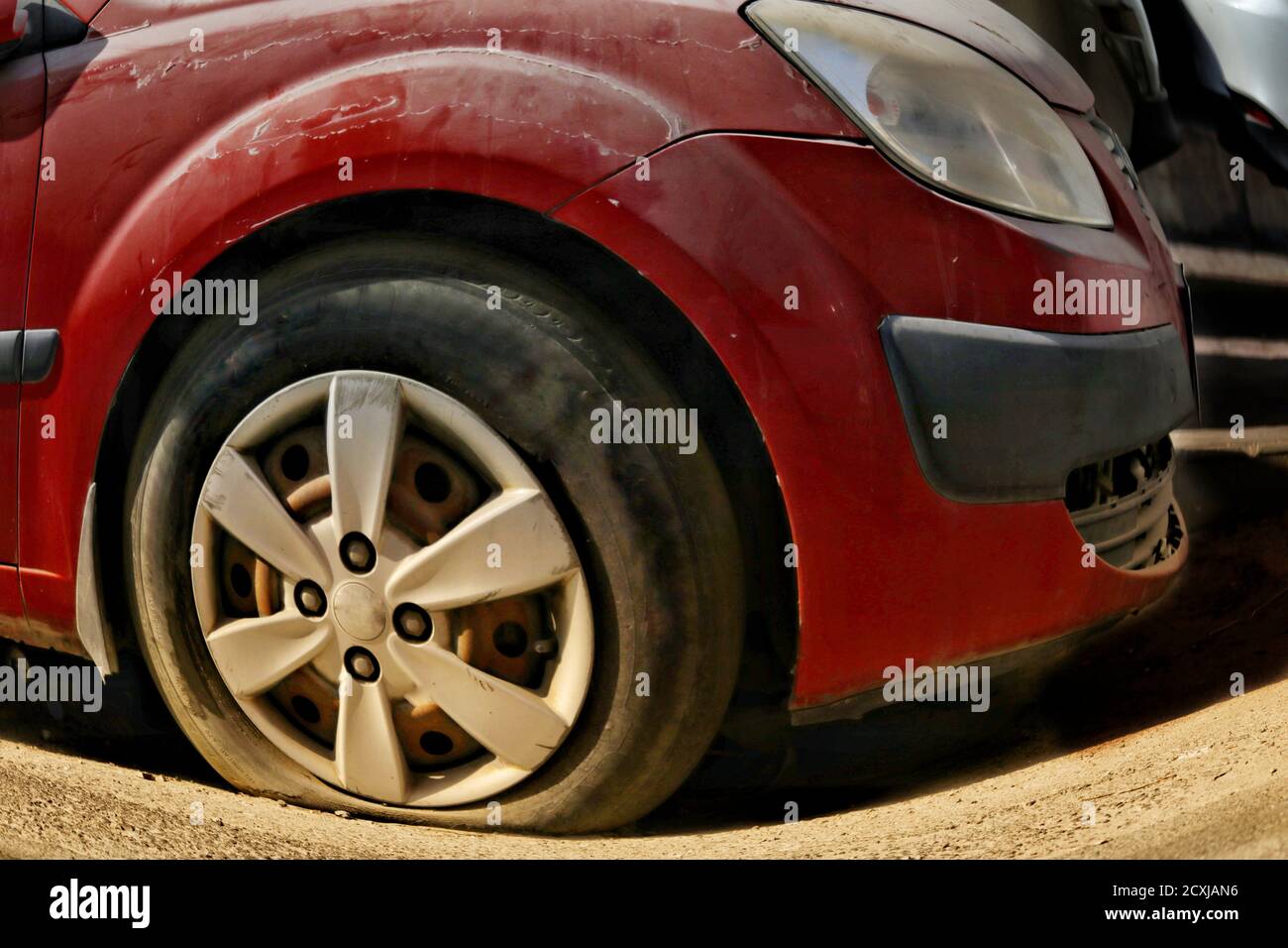 Vista di uno pneumatico della vettura forato. Il trie sgonfio è un problema comune con i veicoli e potrebbe causare incidenti Foto Stock