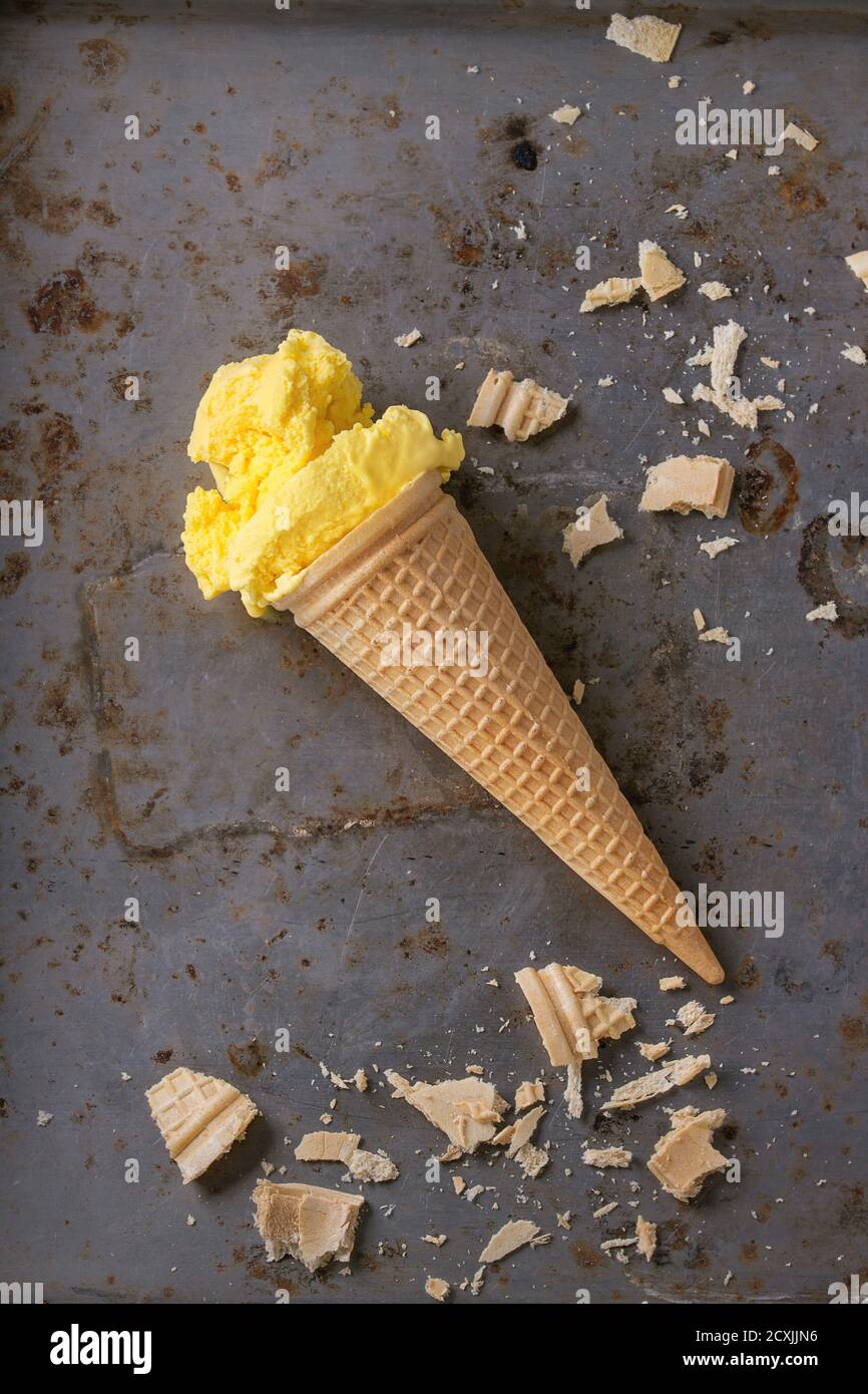 In casa mango gelato in cono di cialda di wafer con mollica su metallo arrugginito textured background. Vista superiore Foto Stock