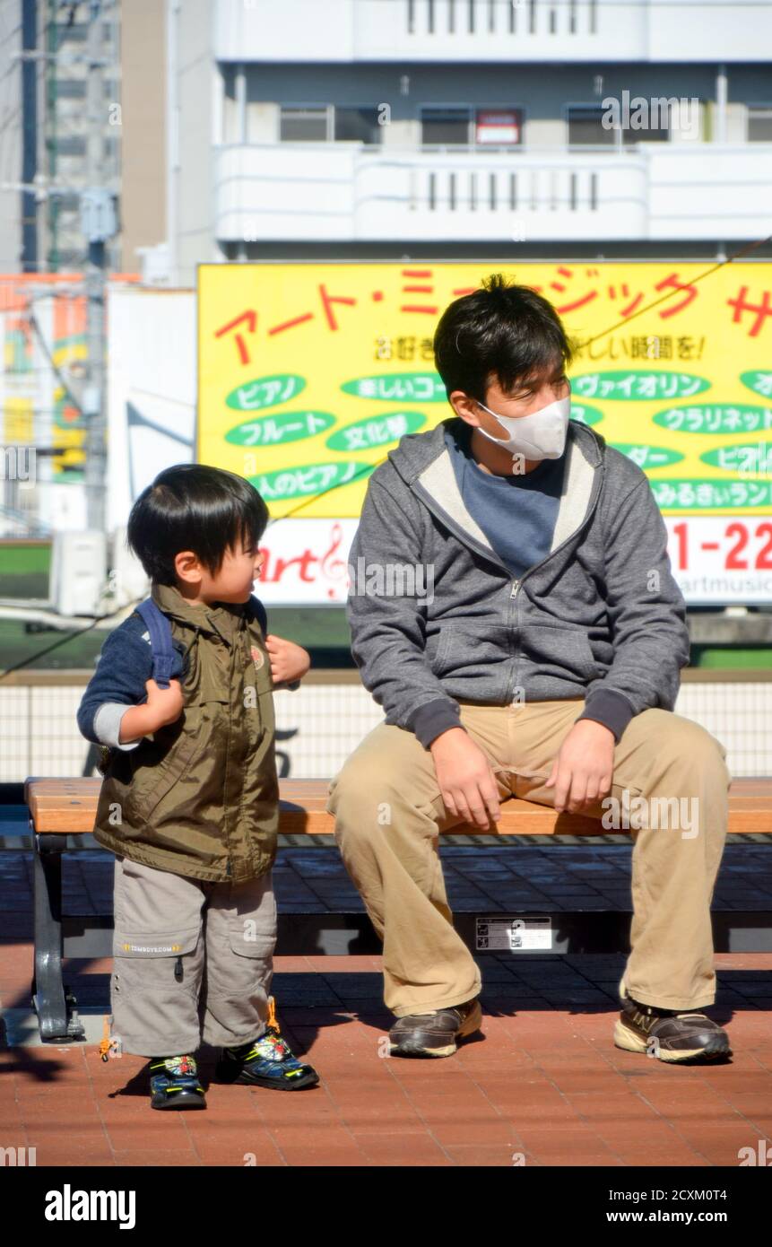 Padre e Figlio in attesa del treno alla stazione di Nagasaki Foto Stock