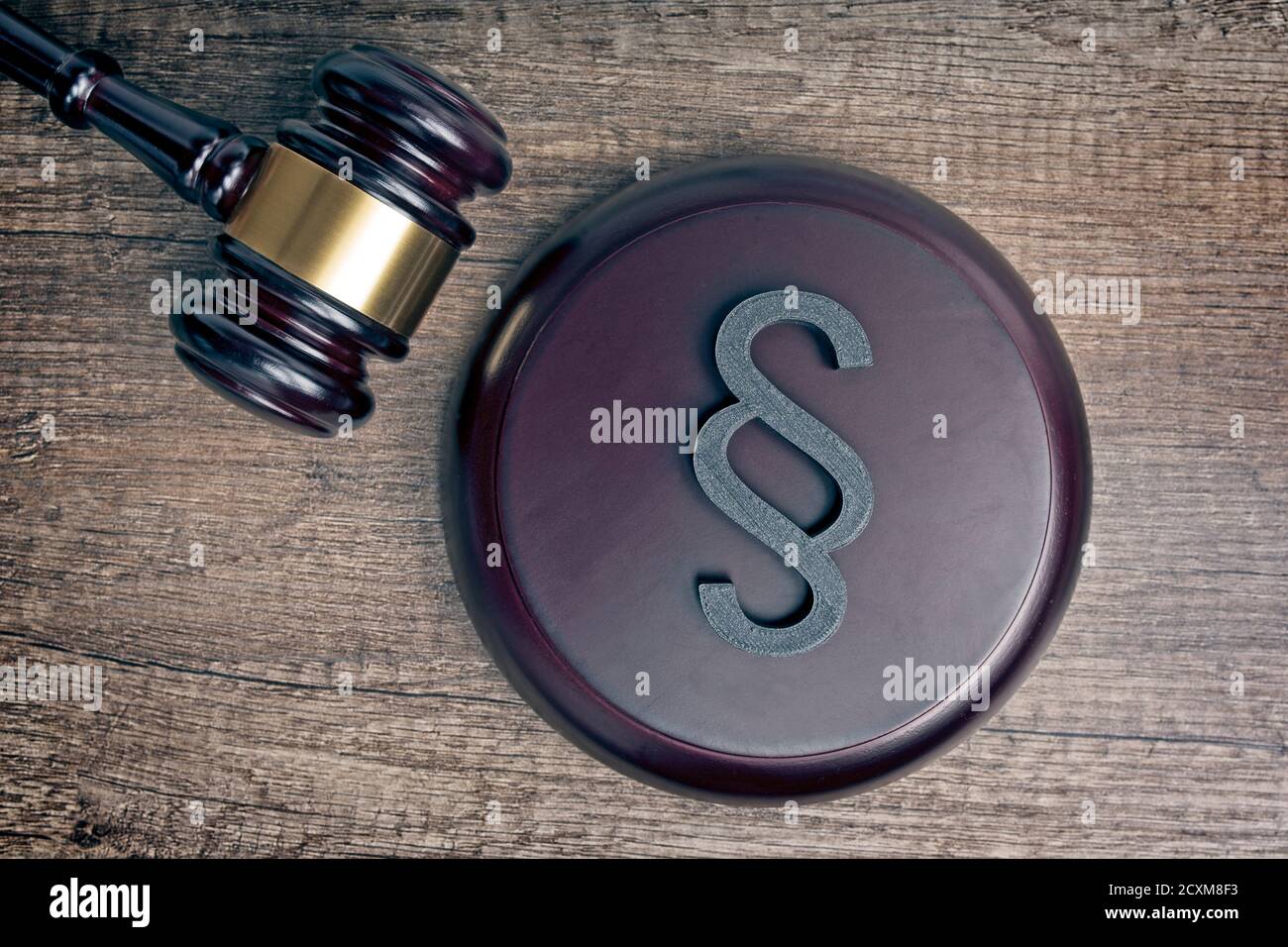 Gavel del giudice di legno accanto ad un segno di paragrafo / sezione come simbolo per l'idea di Justitia e di legge. Foto Stock