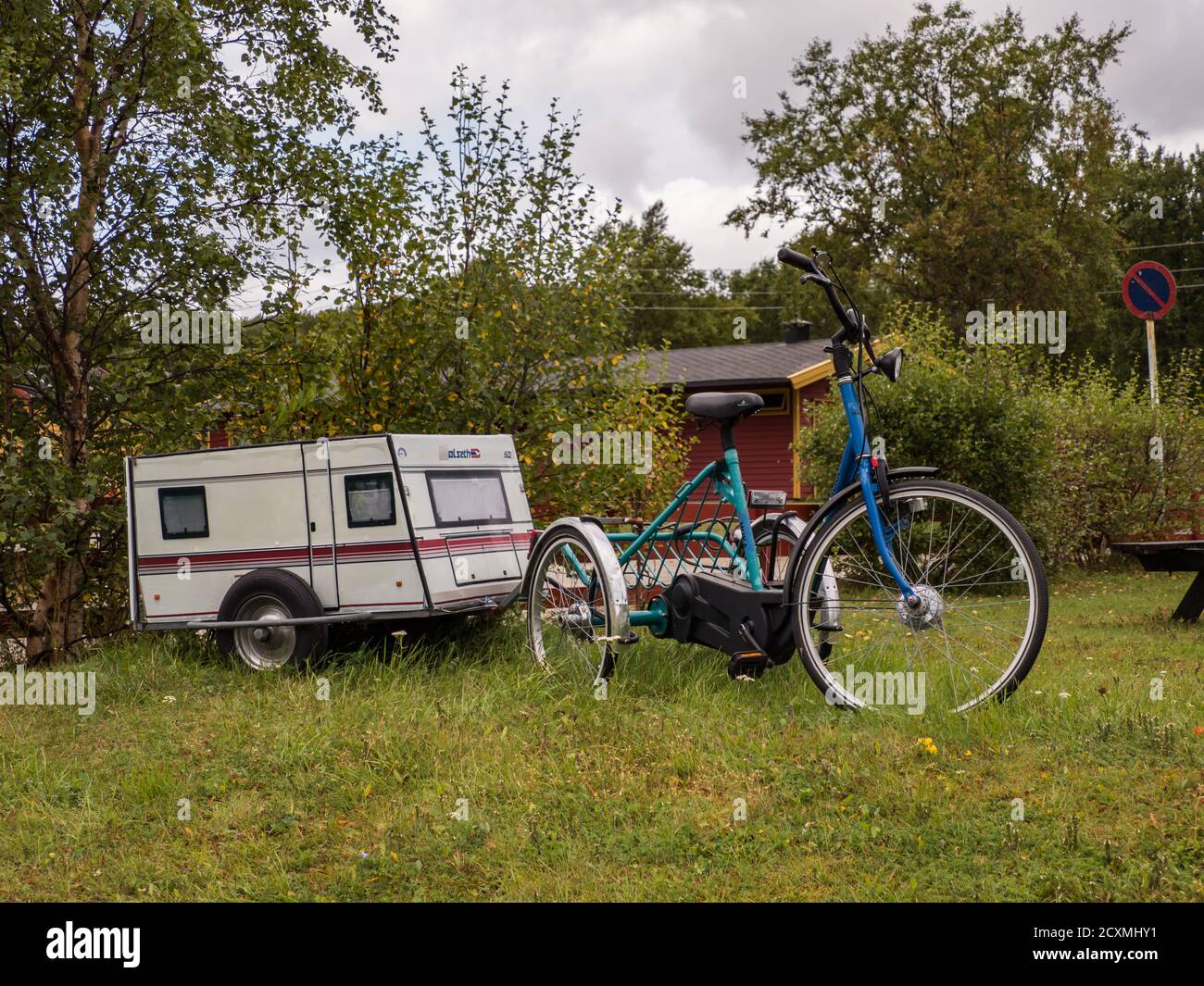 Bodo, Norvegia - 18 agosto 2019: Una bicicletta a tre ruote con una roulotte in miniatura si trova in un campeggio a Geitvagen, vicino a Bodo, Norvegia Foto Stock