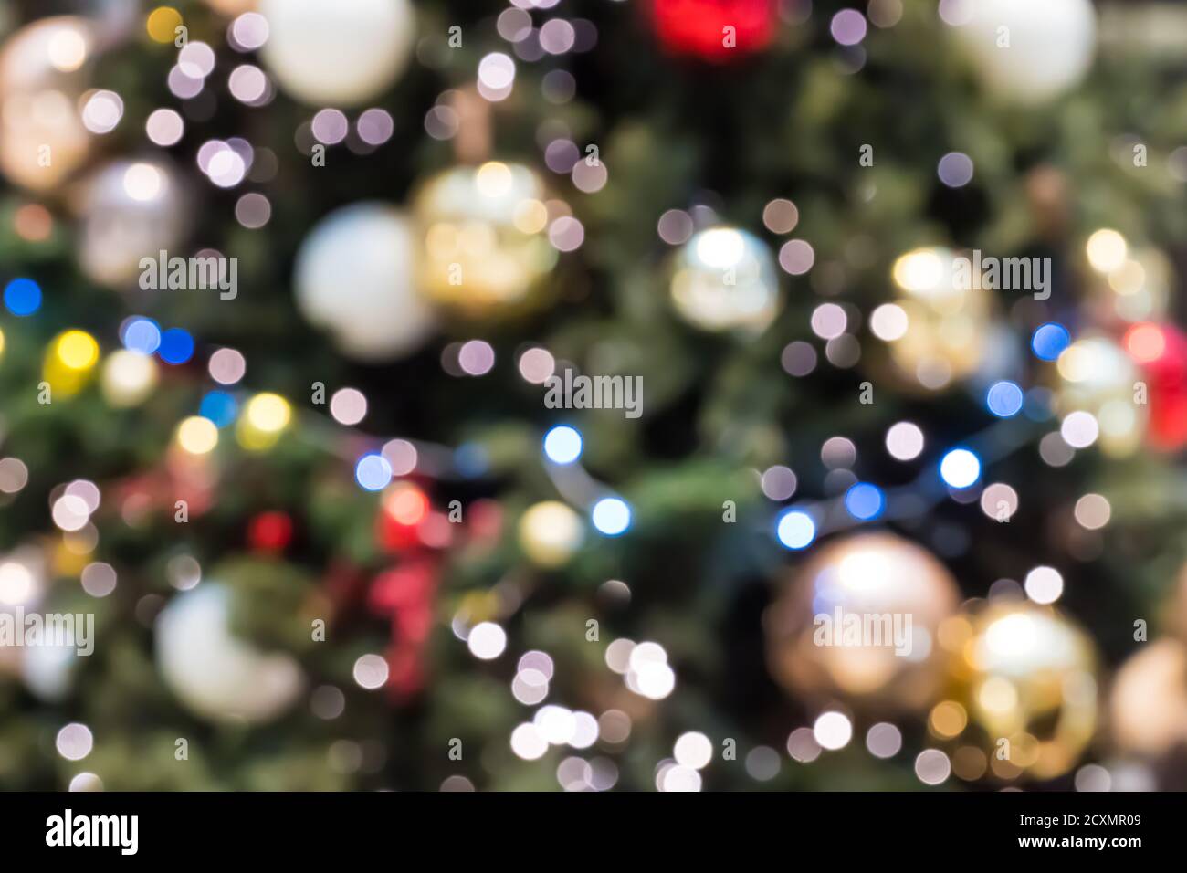 Sfondo delle vacanze sfocato. Sfondo natalizio astratto con luci sfocate. Albero di Natale fuori fuoco con luci incandescenti. Illuminazione da bokeh festosa Foto Stock