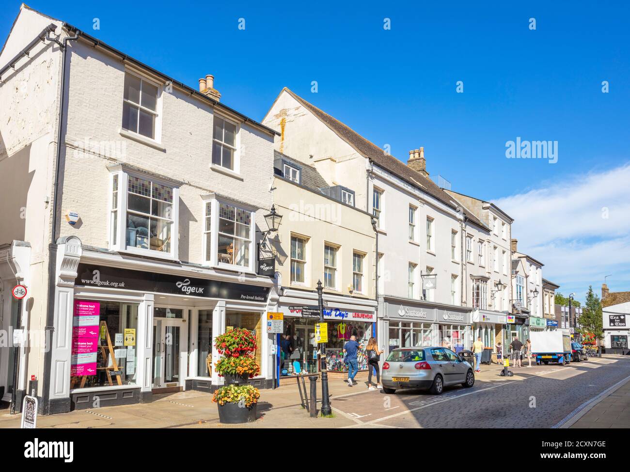 Negozi e auto lungo la High Street Ely Cambridgeshire Inghilterra Regno Unito GB Europa Foto Stock