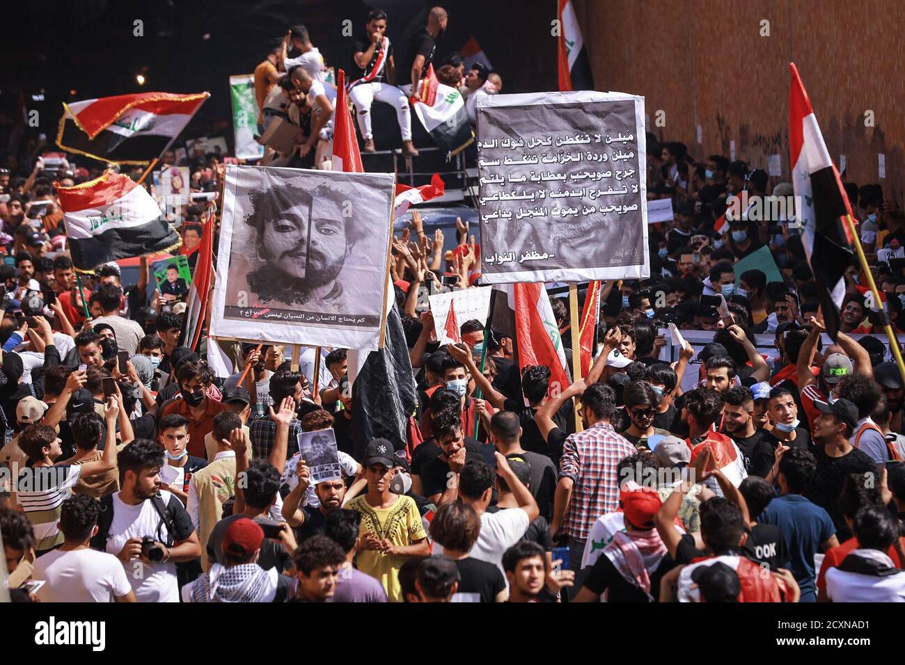 Baghdad, Iraq. 01 Ottobre 2020. I manifestanti iracheni detengono bandiere durante una protesta a Piazza Tahrir, per celebrare il primo anniversario delle manifestazioni anti-governative. Credit: Ameer al Mohammedaw/dpa/Alamy Live News Foto Stock