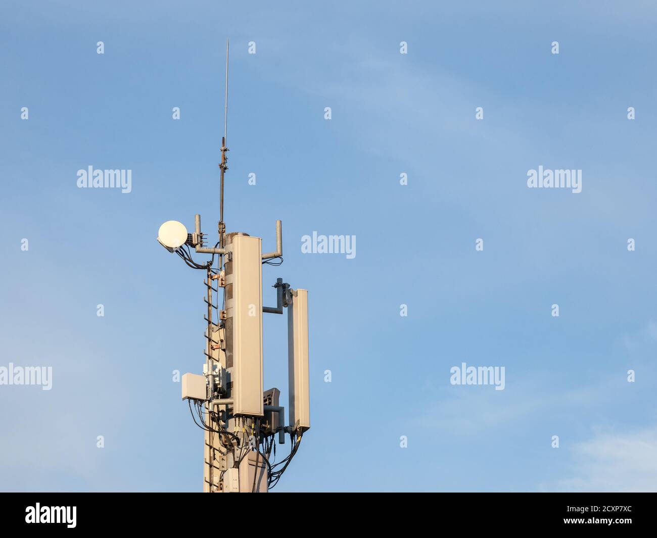 Stazione base per telefoni cellulari, dotata di antenna 3G, 4G e 5G, nella parte superiore di un edificio europeo, utilizzata per la copertura della rete telefonica cellulare e la ricezione Foto Stock
