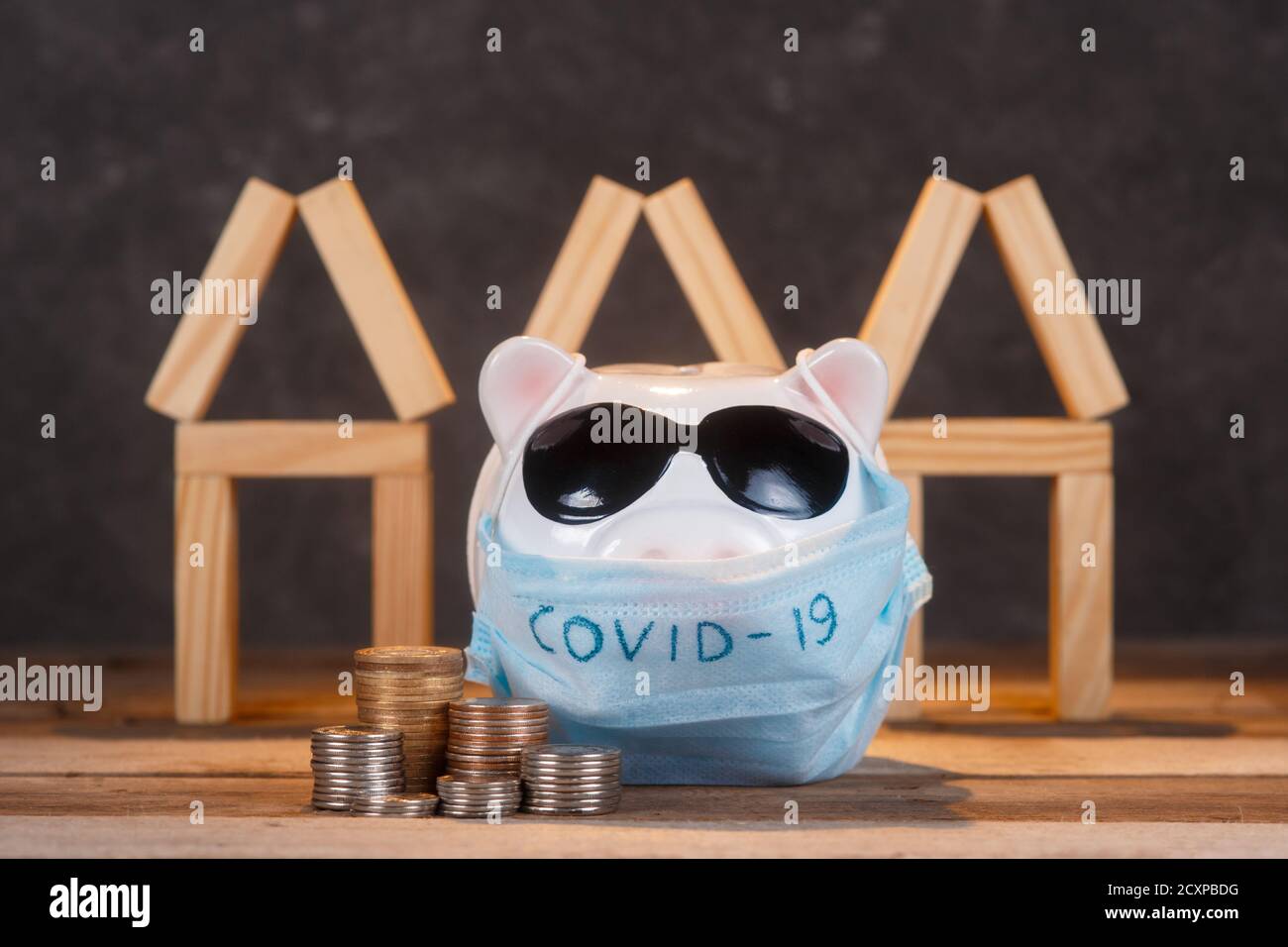 pandemia crisi immobiliare. mascherato piggy banca Foto Stock