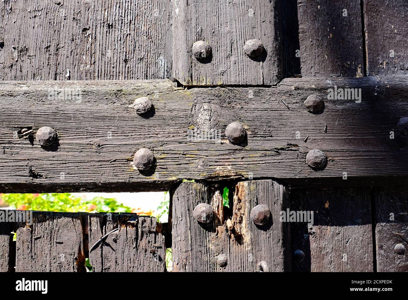 vecchia porta in legno con prigionieri in metallo danneggiati dal tempo. Foto di alta qualità Foto Stock