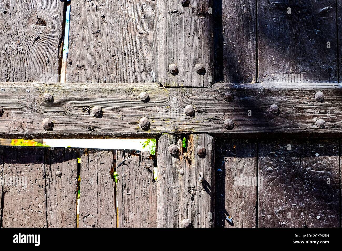 vecchia porta in legno con prigionieri in metallo danneggiati dal tempo. Foto di alta qualità Foto Stock