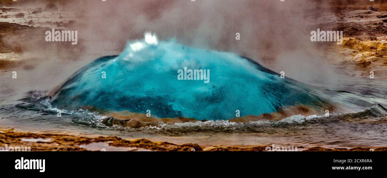 Geyser in Islanda eruzione inizia dapprima formando una bolla di acqua calda prima di scoppiare in aria Foto Stock